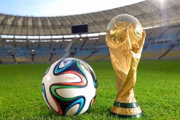 World cup trophy and soccer ball on field