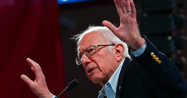 Bernie Sanders with both hands raised