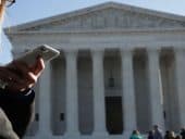 woman betting on her cell phone in front of US Supreme Court