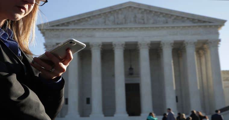 woman betting on her cell phone in front of US Supreme Court