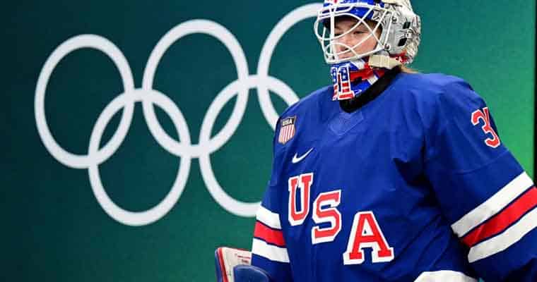 A USA Hockey player in front of the five Olympic rings