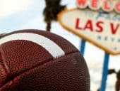 A football in front of the Los Vegas sign