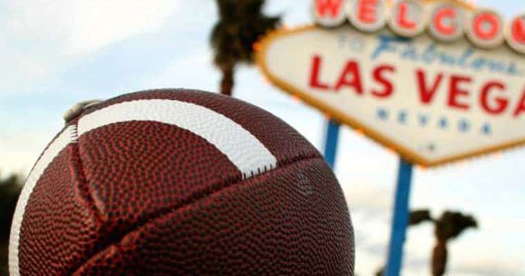 A football in front of the Los Vegas sign