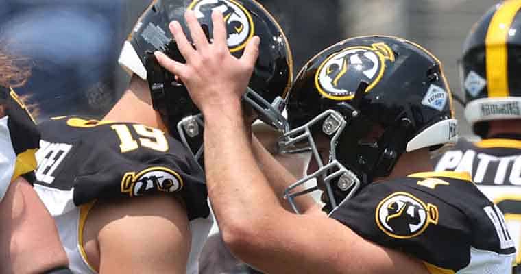 two Pittsburgh Maulers players banging their helmets together