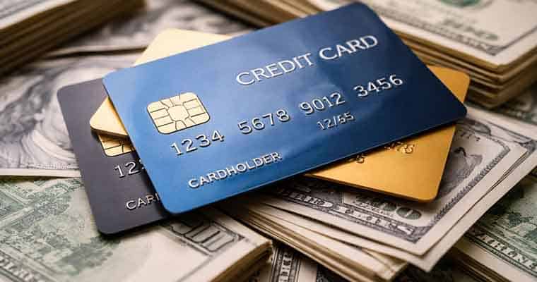 a pile of cash with credit cards on top