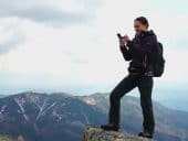 woman gambling on cell phone on a mountaintop