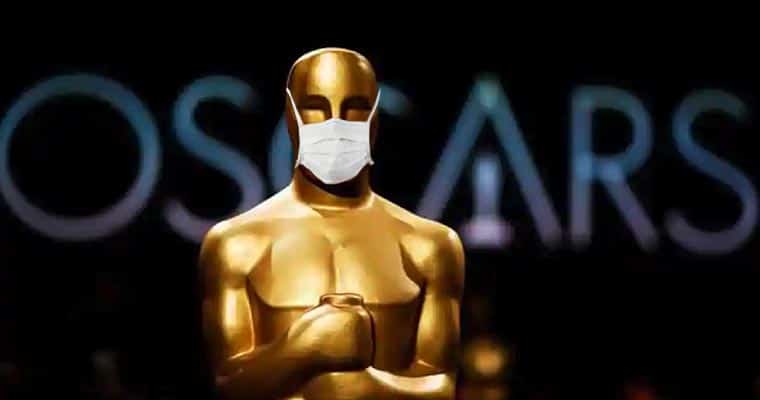 An Oscar Award statue with a surgical mask