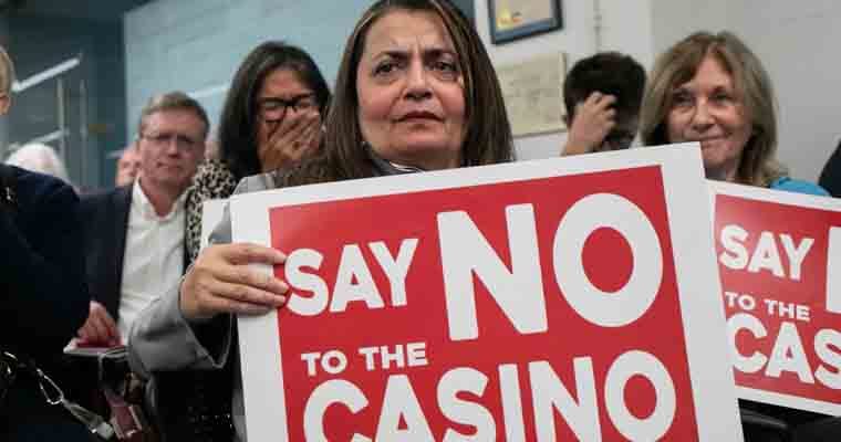 Protestors holding signs agains Freedom Plaza casino